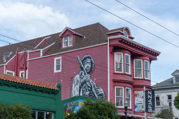 A red building with a mural of a man holding a gun